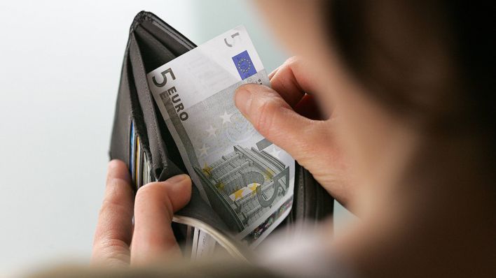 Eine Frau nimmt einen Geldschein aus einem Portemonnaie © imago images/photothek