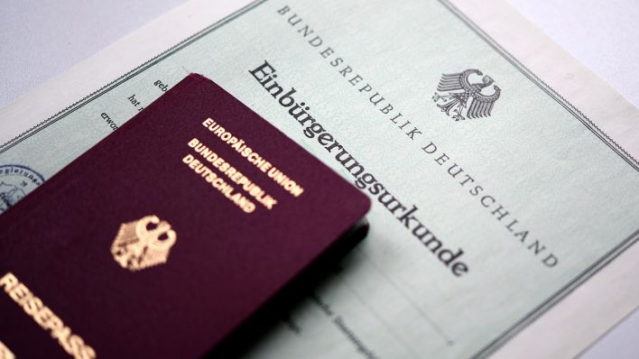 Eine Einbürgerungsurkunde zusammen mit dem deutschen Reisepass