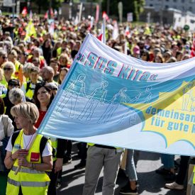 Streikende halten ein Banner mit der Aufschrift "SOS Kita".