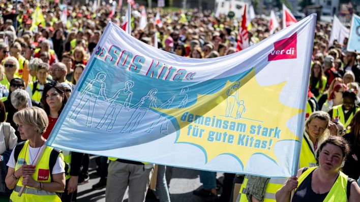 Streikende halten ein Banner mit der Aufschrift "SOS Kita".