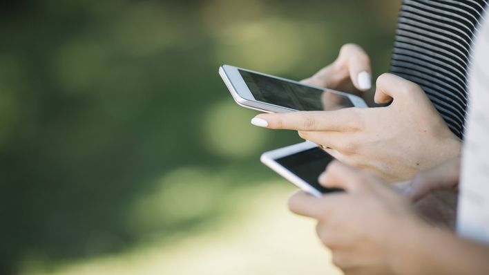 Zwei Frauen tippen auf ihren Smartphones