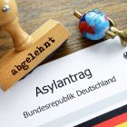 Ein Stempel mit Aufschrift "abgelehnt" liegt auf einem Asylantrag © imago/Christian Ohde