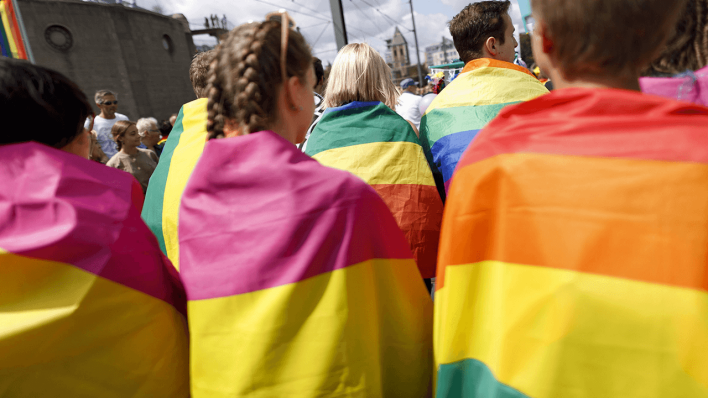 Jugendlich haben sich beim CSD in Regenbogenfahnen eingewickelt © imago images/Future Image