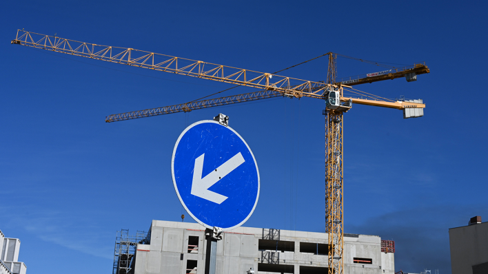 Kran auf einer Baustelle hinter einem Verkehrsschild © IMAGO / Petra Schneider