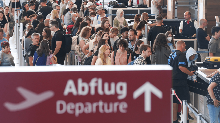 Zahlreiche Passagiere stehen in einer Schlange bei der Sicherheitskontrolle am Flugafen BER © dpa/Joerg Carstensen