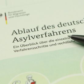 Informationsbroschüre vom Bundesamt für Migration und Flüchtlinge über den Ablauf des deutschen Asylverfahrens. © IMAGO / Hanno Bode