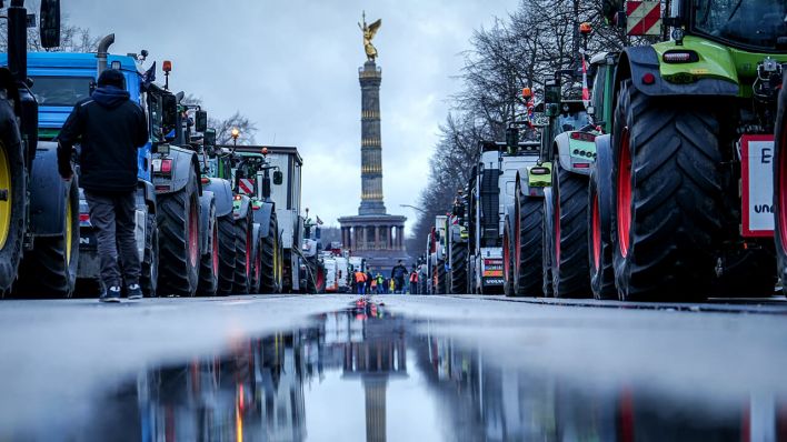 Die Siegessäule und Traktoren spiegeln sich in einer großen Pfütze © dpa/Kay Nietfeld