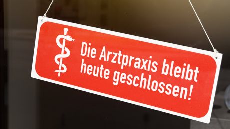 Schild an einer Eingangstür mit Aufschrift "Die Arztpraxis bleibt heute geschlossen" © IMAGO / Christian Ohde