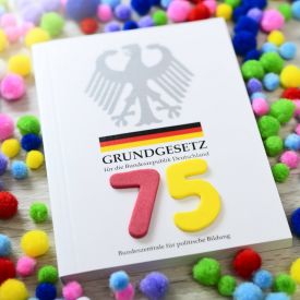 Deutsches Grundgesetz mit der Zahl 75 © IMAGO / Christian Ohde