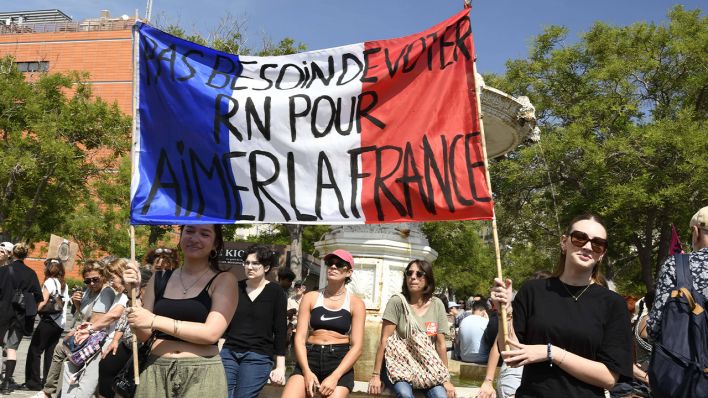 Zwei Frauen halten ein Banner mit der Aufschrift "nicht nötig RN zu wählen, um Frankreich zu lieben" bei einer Demonstration am Wochenende in Marseille.