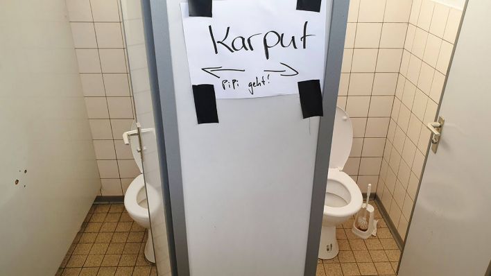 Vor Toiletten hängt ein Zettel mit fehlerhafter Aufschrift: "Karput, Pipi geht" © imago images/blickwinkel