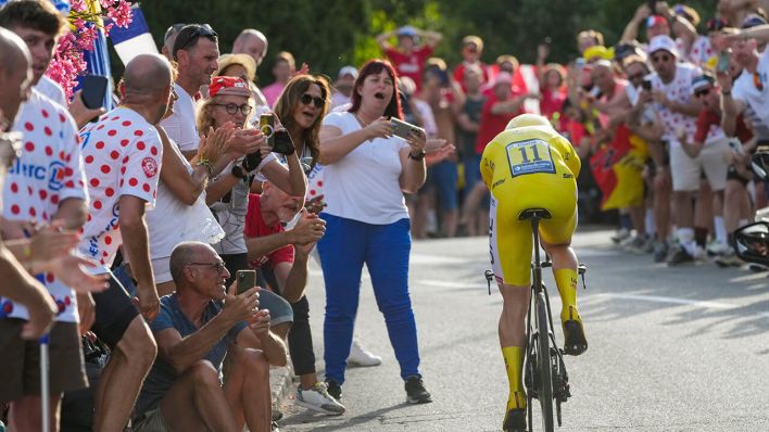 Tadej Pogacar fährt im Gelben Trikot an Fans während der Tour de France vorbei © AP Photo/Jerome Delay