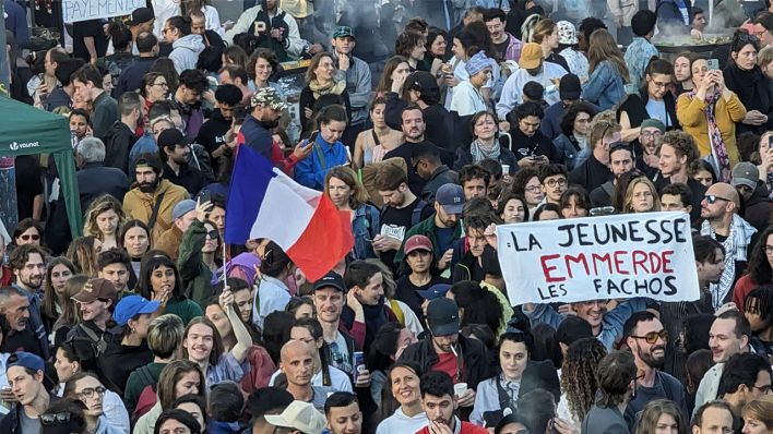 "Die Jugend scheißt auf die Faschos" heißt es auf einem Transparent am Abend in Paris, wo Menschen den Wahlausgang für das linksgrüne Bündnis NFP nach der zweiten Runde der Parlamentswahlen feiern.