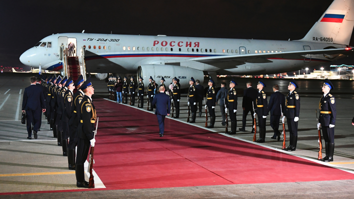 Gefangenen-Deal: Russlands Präsident Putin, mit dem Rücken zur Kamera, trifft auf dem Regierungsflughafen außerhalb von Moskau ein, um freigelassene russische Gefangene in Empfang zu nehmen © picture alliance/dpa/Sputnik Kremlin Pool via AP