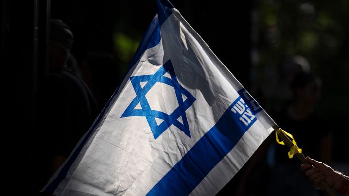 Ein Mann mit einer Israel-Flagge in Tel Aviv © AP Photo/Leo Correa