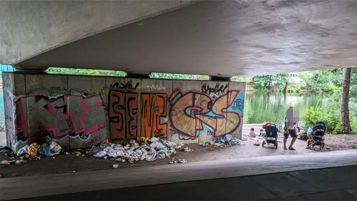 Menschen und Müllberge unter einer Brücke am Kanalufer Tegel © rbb