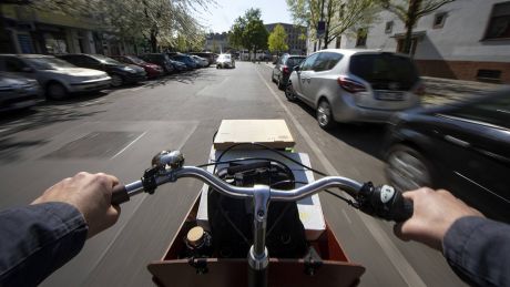 Ein Mann fährt mit einem beladenen Lastenrad auf der Straße (Symbolbild) © imago images/photothek