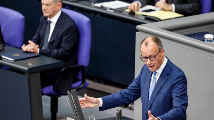 CDU-Fraktionschef Friedrich Merz spricht im Bundestag, im Hintergrund Bundeskanzler Olaf Scholz (Foto: IMAGO / Jochen Eckel)