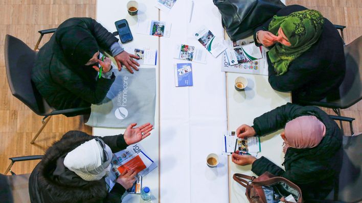 Frauen mit migrantischen Hintergrund sitzen an einem Tisch und reden miteinander (Symbolbild) © imago images/Jochen Eckel