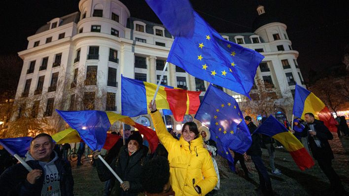 Menschen schwenken rumänische und EU-Flaggen während einer pro-europäischen Kundgebung in Bukarest © Andreea Alexandru/AP/dpa