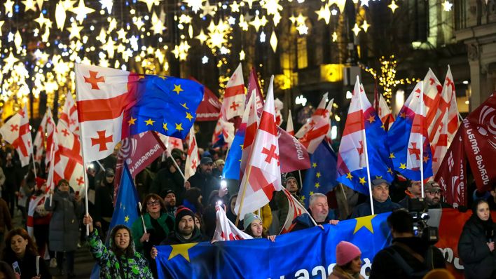 Demonstranten mit georgischen National- und EU-Fahnen nehmen an einer regierungskritischen Kundgebung vor dem Parlamentsgebäude in Tiflis teil © Zurab Tsertsvadze/AP/dpa