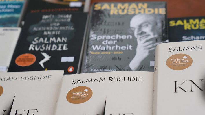 Bücher des Schriftstellers Salman Rushdie stehen vor der Lesung seines neuen Buches "Knife. Gedanken nach einem Mordversuch" im Deutschen Theater auf einer Auslage zum Verkauf